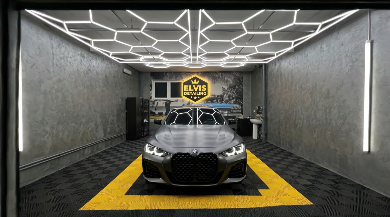 Boxa de lucru Elvis Detailing: BMW gri mat sub tavanul cu LED-uri hexagonale, pe dalele cu chenar galben