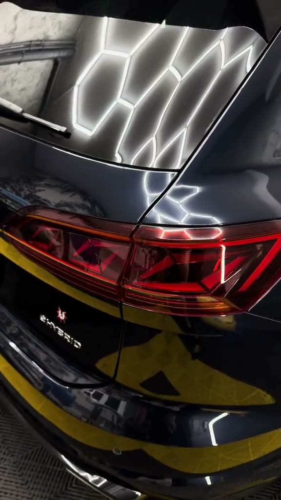 Lateral spate de VW Touareg cu lac lucios protejat, pe podeaua cu dale galbene a atelierului