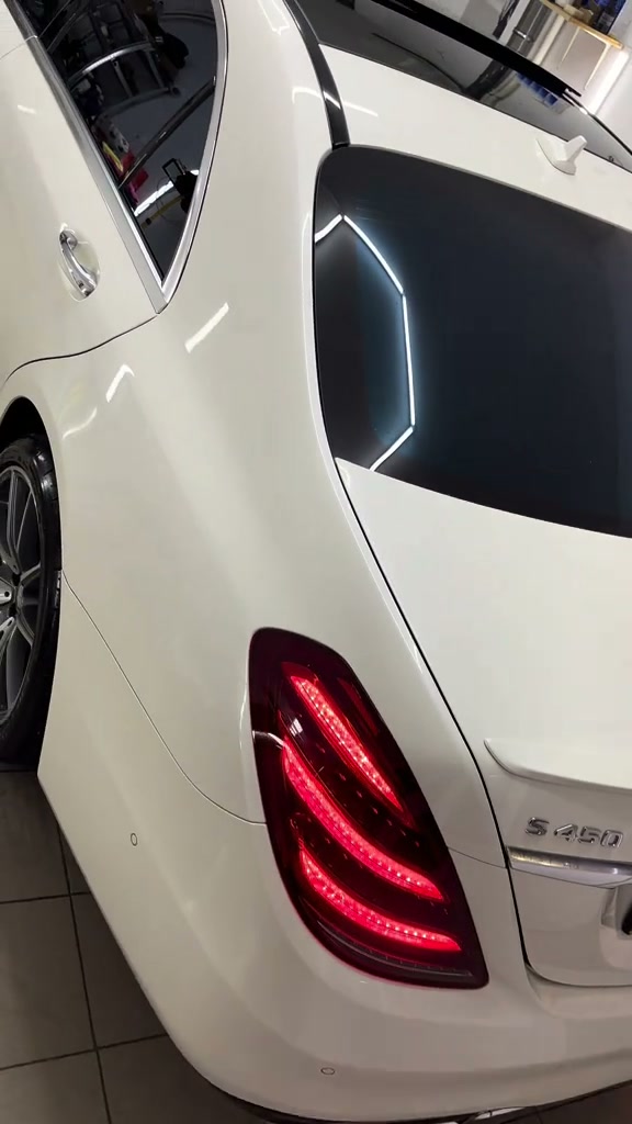 Mercedes S-Class alb cu lac lucios, văzut din spate în atelier