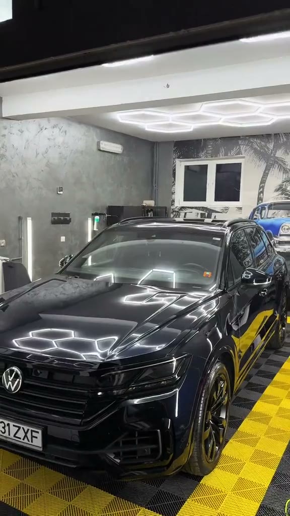 Capotă neagră de VW Touareg cu reflexii clare ale luminilor hexagonale, după corecție lac în atelier